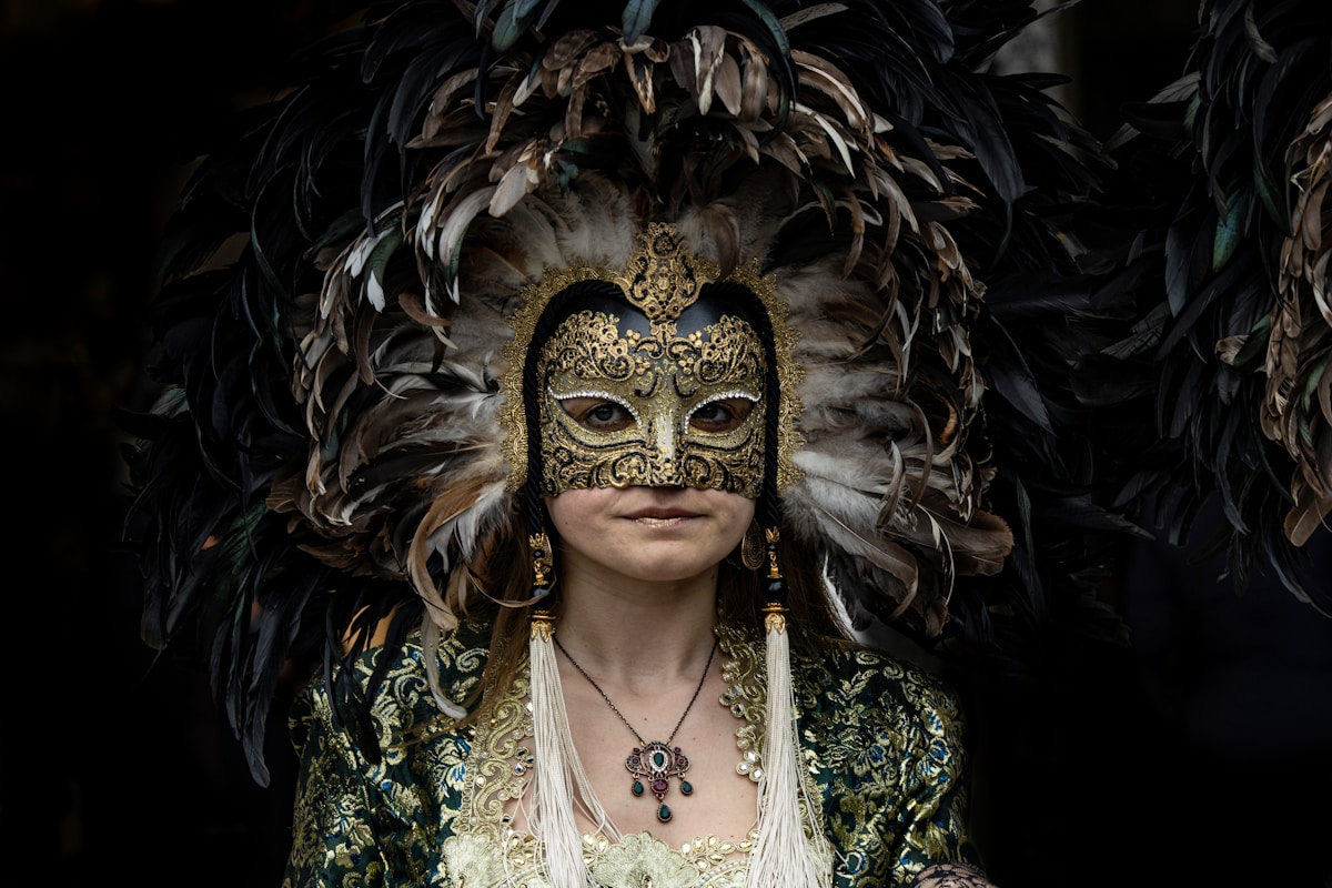 Woman wearing an ornate golden carnival mask with dramatic dark feather headdress