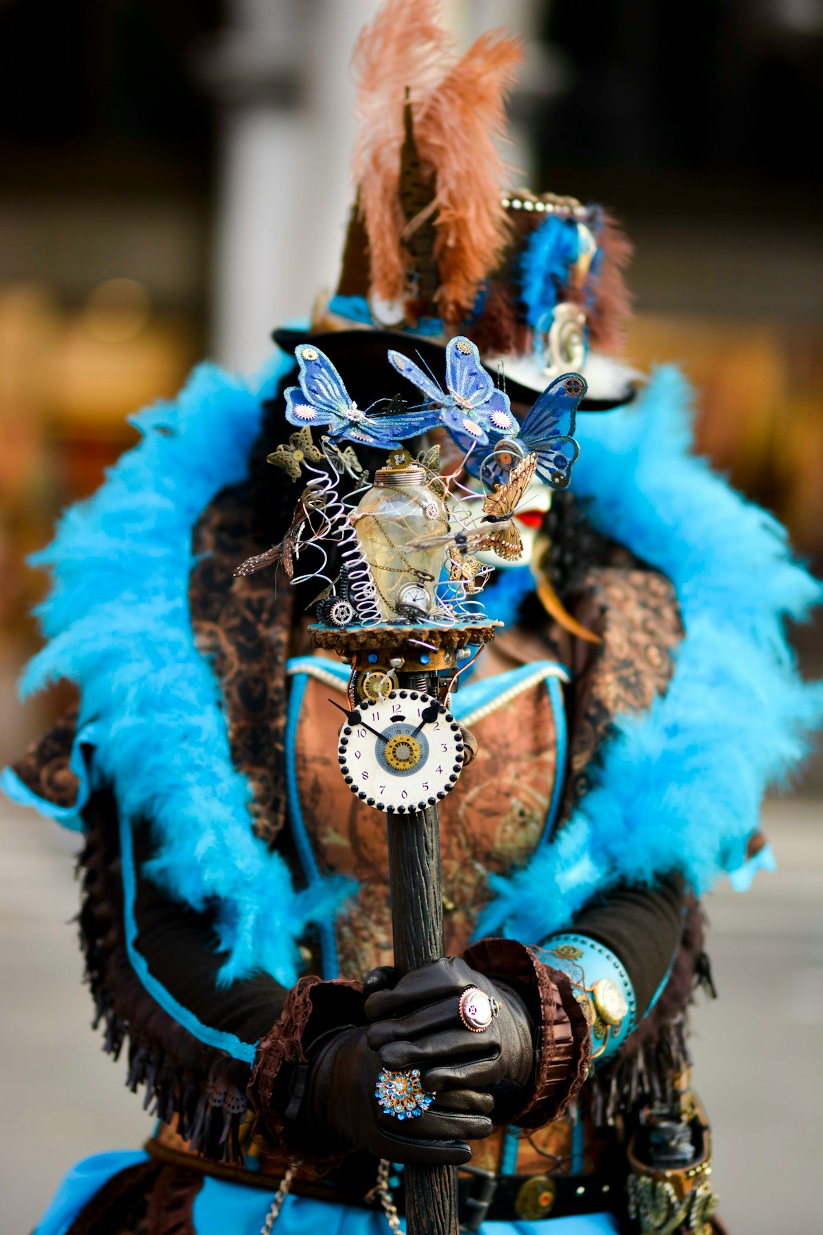Elaborate steampunk-inspired carnival costume with blue feathers and ornate mask at the Venice Carnival