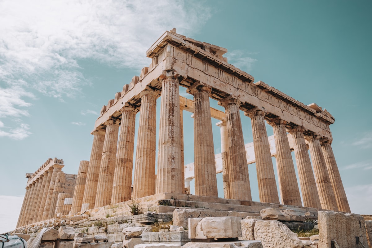 Ancient Greek temple ruins with stone columns against a clear sky, remnants of pre-classical civilization in the Aegean