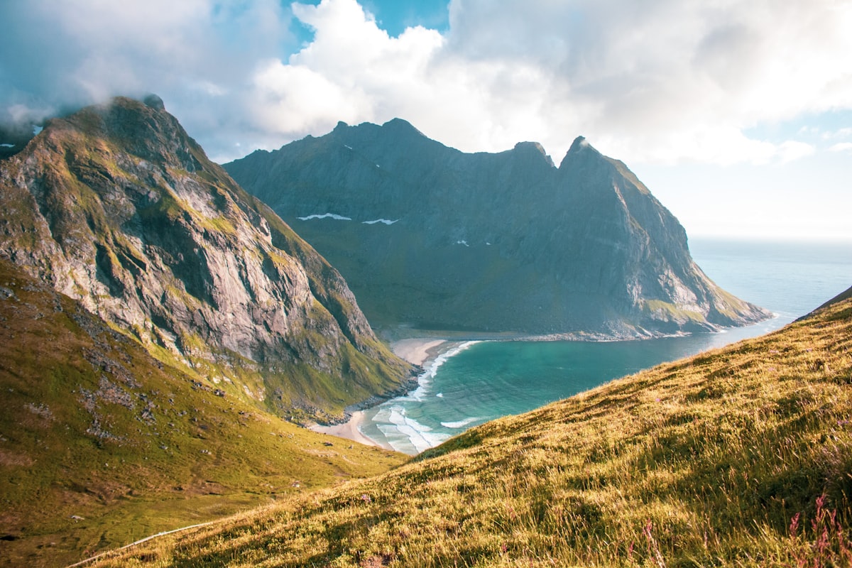 White sand beach with dramatic mountain peaks rising behind it in the Lofoten Islands, Norway