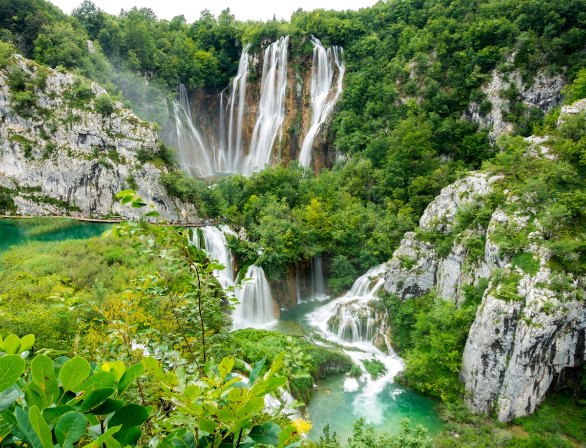 Cascading waterfalls flowing through lush green forest at Plitvice Lakes National Park in Croatia