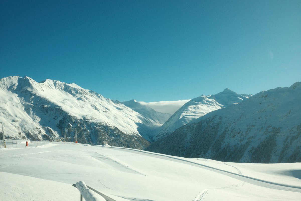 Fresh snow covering a high glacier bowl with a ski lift line climbing toward the ridge