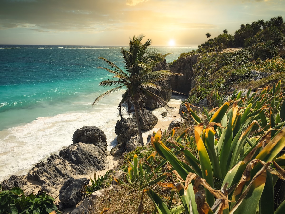 Ancient Mayan ruins perched on a cliff above turquoise Caribbean waters at Tulum Beach, Mexico