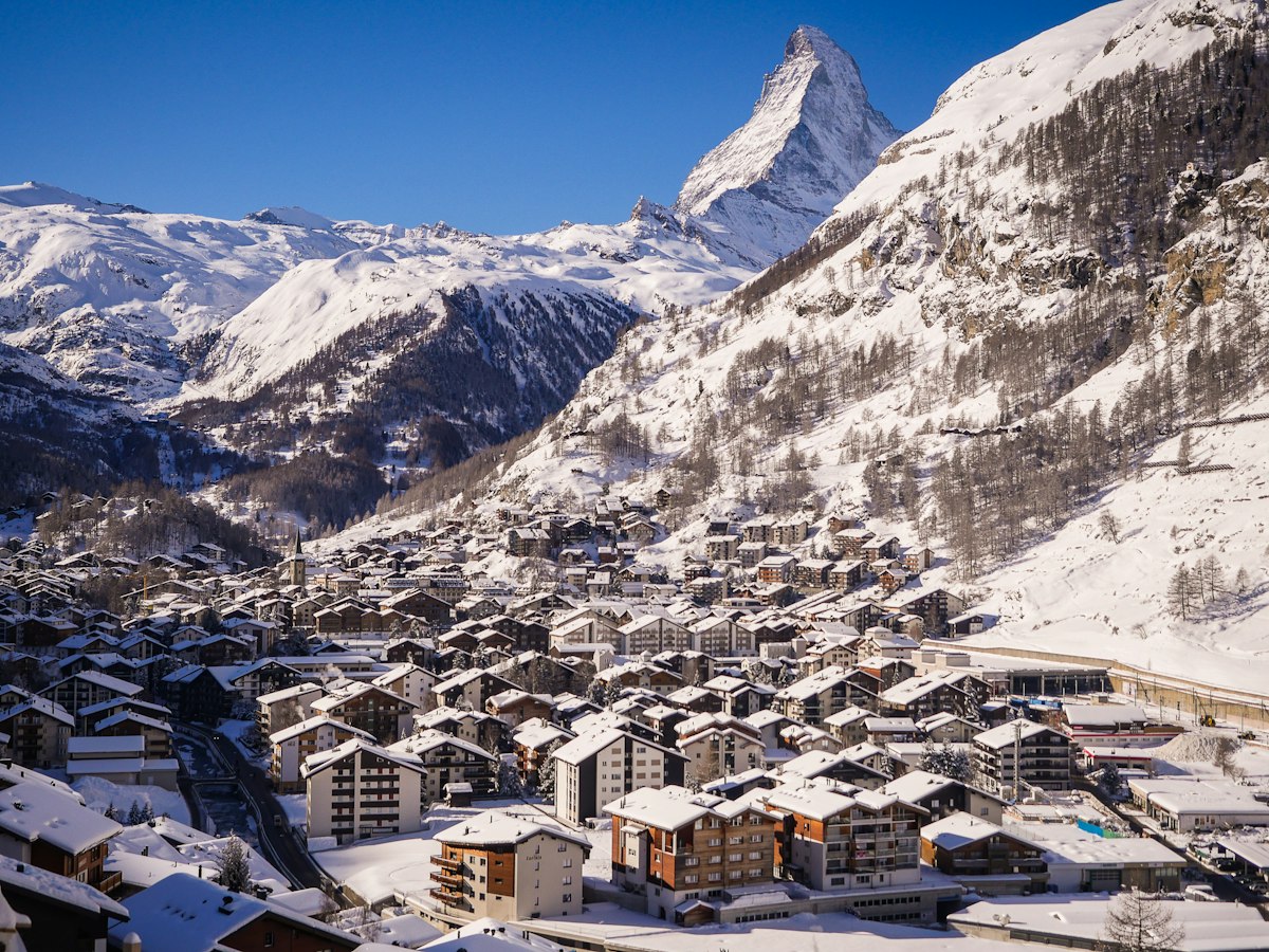 Wooden chalets of car-free Zermatt in deep snow with the Matterhorn towering over the valley
